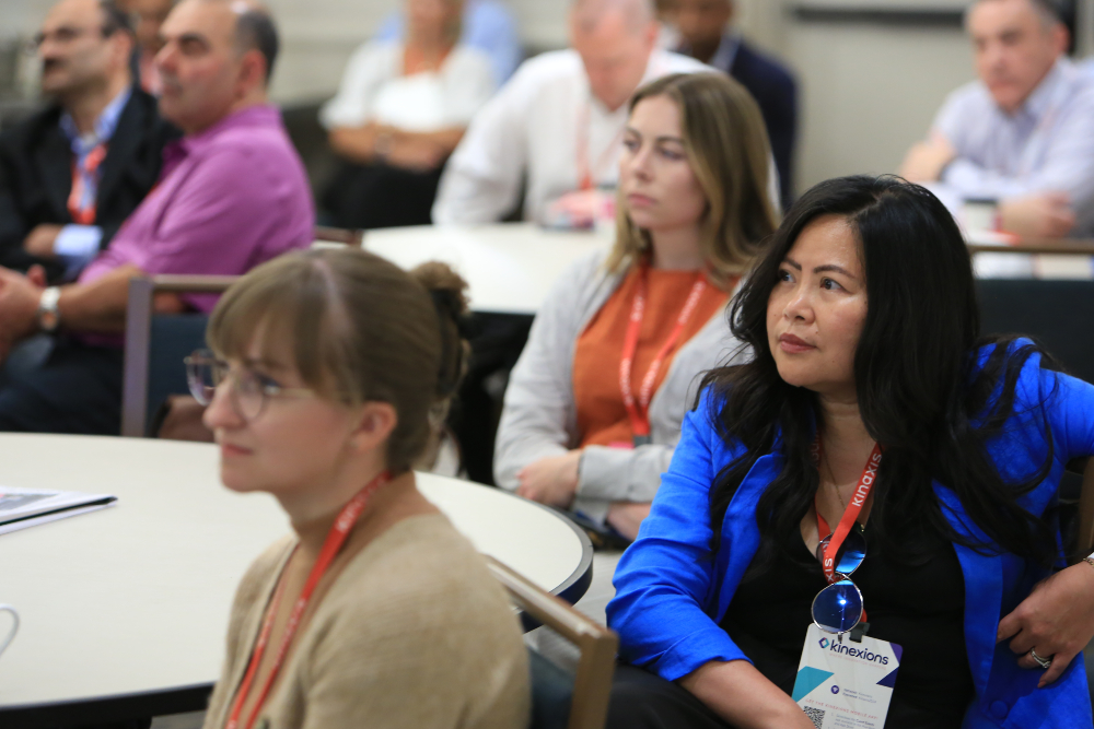 Three female Kinexions attendees listen during a breakout session.