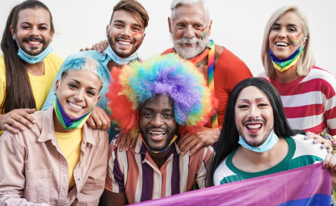 People celebrating Pride month and holding a Pride flag