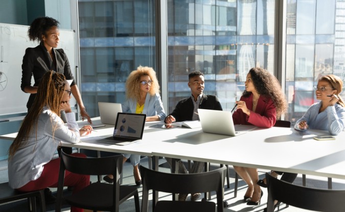 Woman speaking to another woman leading a business meeting.