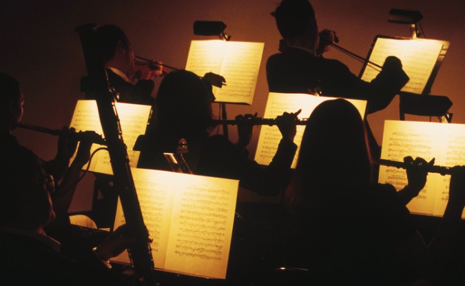 View of symphony orchestra performing from sheet music